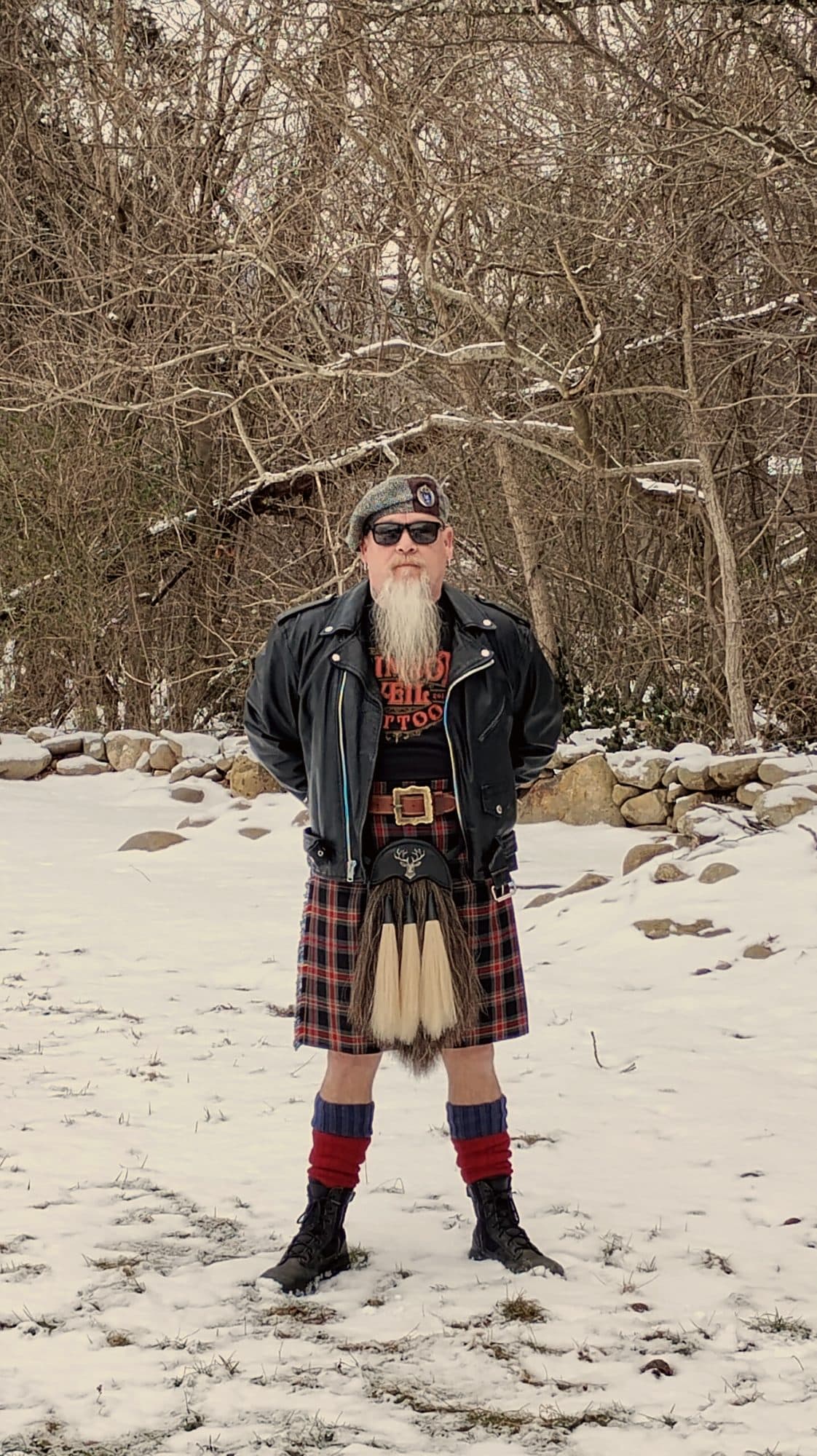 A customer in full Highland dress standing in snow