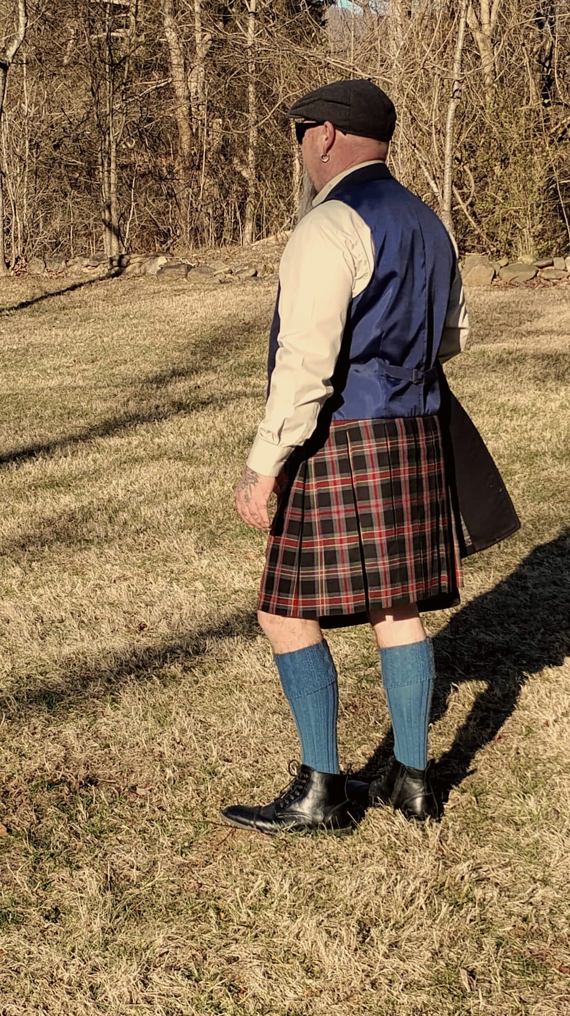 A customer in a blue waistcoat and red kilt